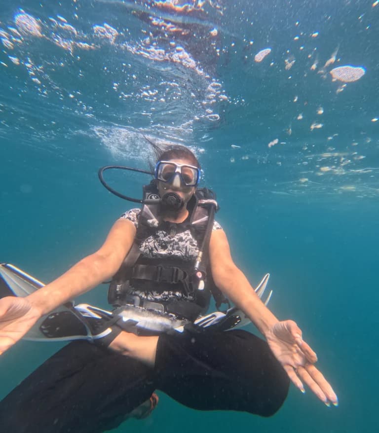 Female diver meditating in lotus position underwater