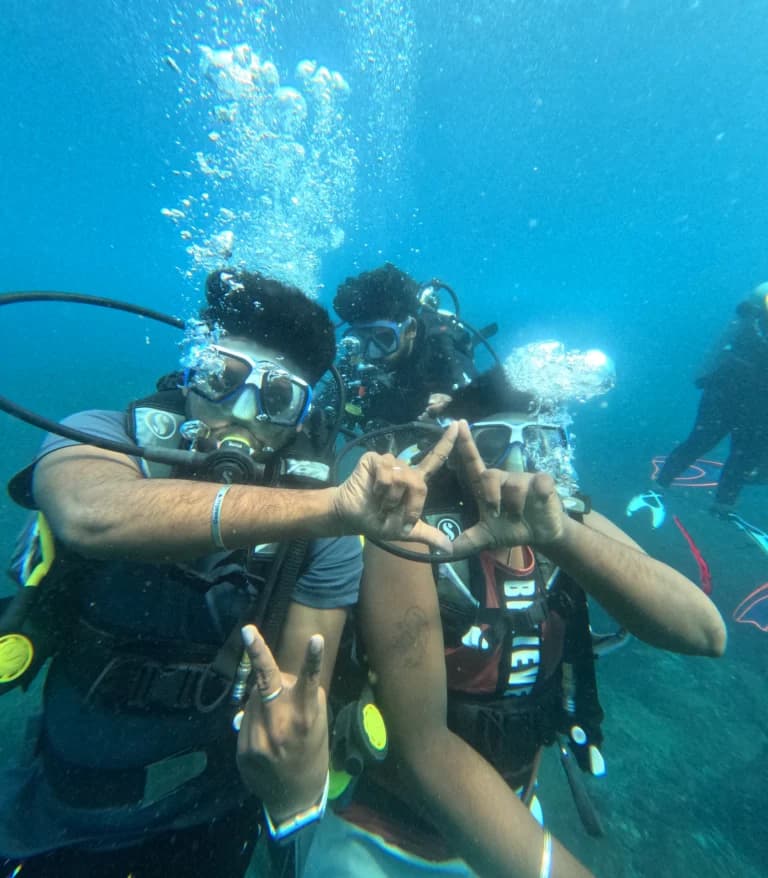 Two divers making a triangle shape with their hands