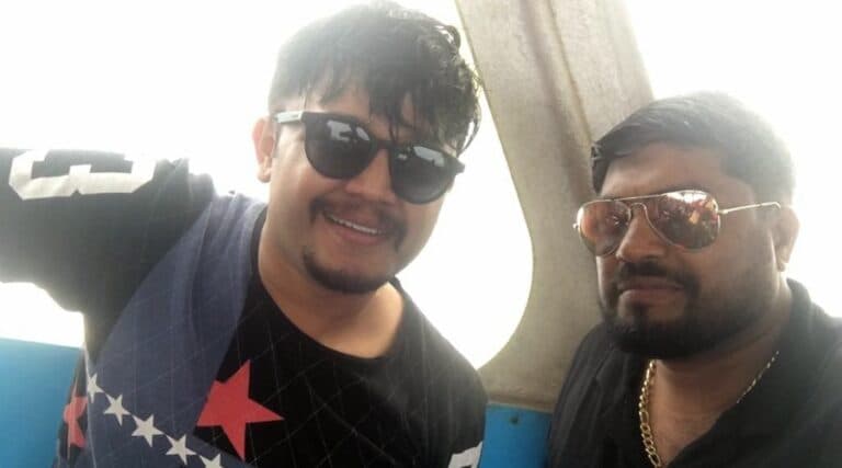 Two men with sunglasses taking a selfie on the boat deck