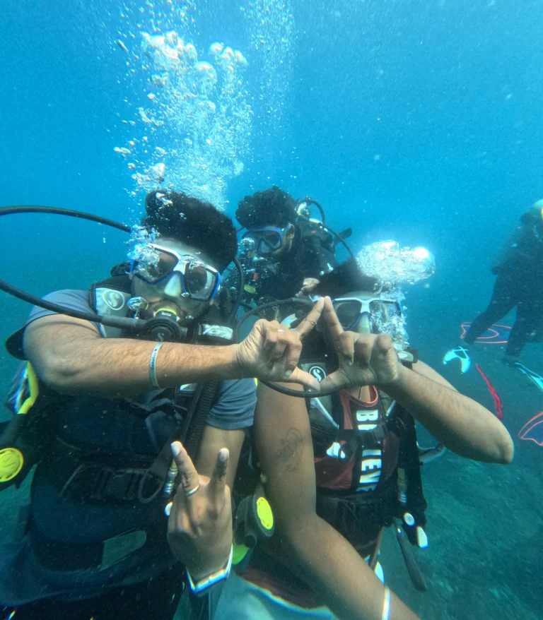 Two divers making a triangle shape with their hands